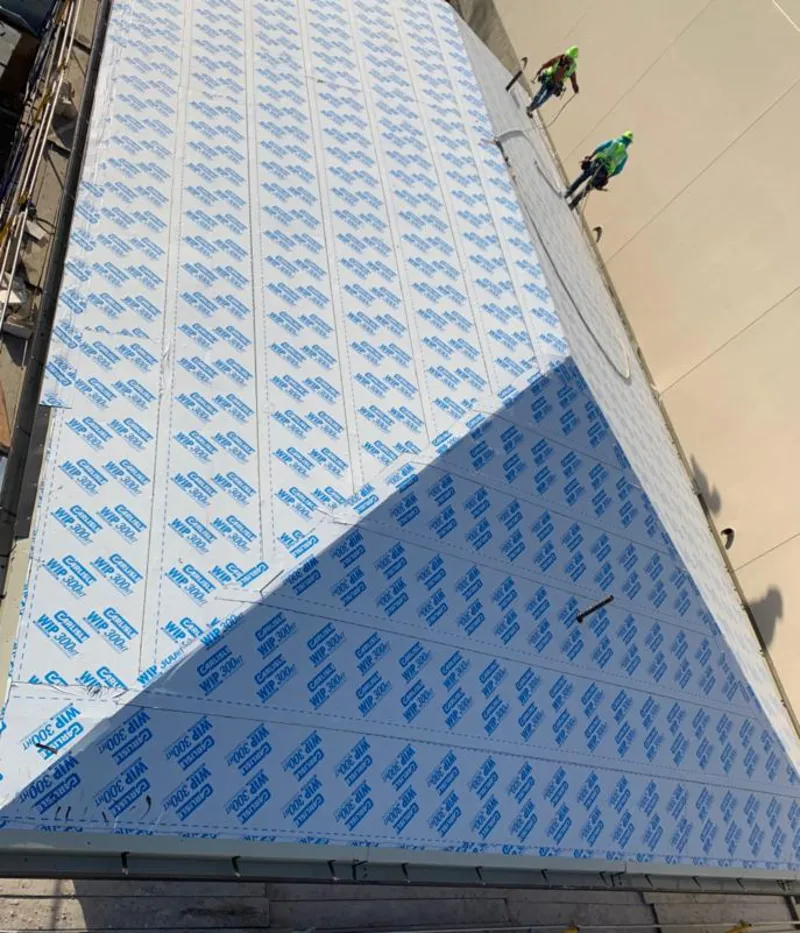 Professional roofers installing underlayment on a metal roof in Haledon